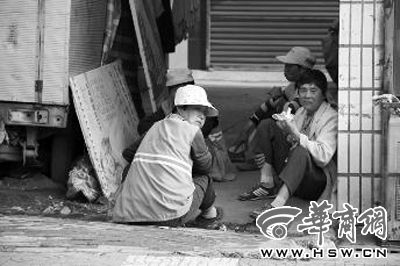 5月26日下午，汉中市4名环卫工人坐在阴凉处“享受”晚餐——白面馍馍 本报记者 陈兴王 摄